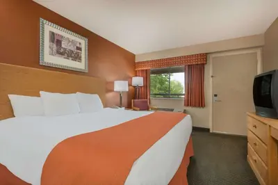 a hotel room with a large bed and a television at Days Inn by Wyndham Columbus Fairgrounds in Columbus