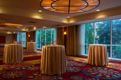 a row of tables in a room with large windows at Wyndham Cleveland Airport in Cleveland