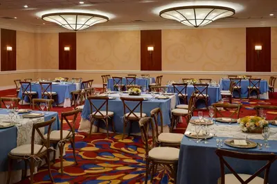 a banquet hall with blue tables and chairs at Wyndham Cleveland Airport in Cleveland