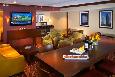 a restaurant with a table and chairs and a television at Wyndham Cleveland Airport in Cleveland