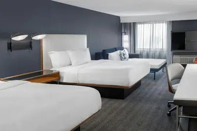a hotel room with two beds and a desk at Courtyard Cleveland Airport South in Middleburg Heights