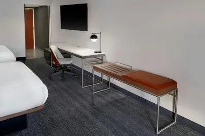 a hotel room with a desk and a bed at Courtyard Cleveland Airport South in Middleburg Heights