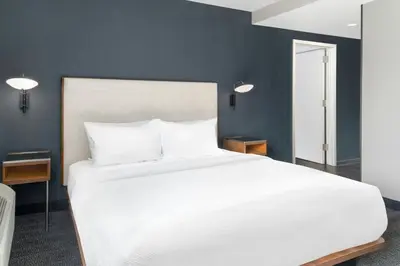 a large white bed in a room with blue walls at Courtyard Cleveland Airport South in Middleburg Heights