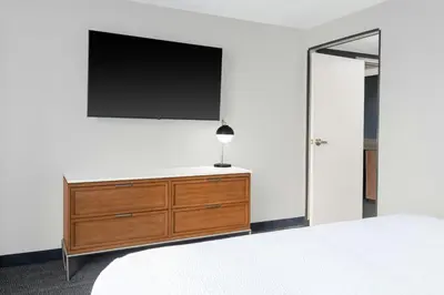 a bedroom with a dresser with a flat screen tv on the wall at Courtyard Cleveland Airport South in Middleburg Heights