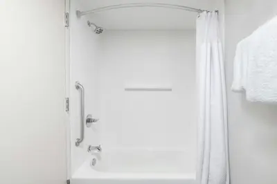 a bathroom with a shower with a white shower curtain at Courtyard Cleveland Airport South in Middleburg Heights
