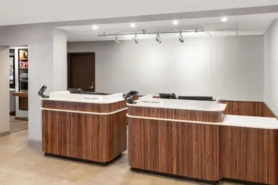 a lobby with two reception desks in a building at Courtyard Cleveland Airport South in Middleburg Heights