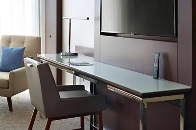 a desk in a hotel room with a lamp and a chair at Marriott at the University of Dayton in Dayton