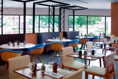 a restaurant with tables and chairs and windows at Marriott at the University of Dayton in Dayton