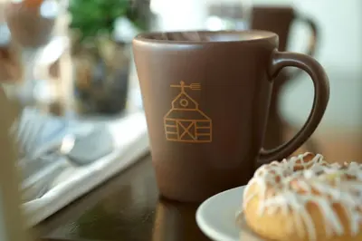 a coffee cup sitting on a table next to a doughnut at Marriott at the University of Dayton in Dayton
