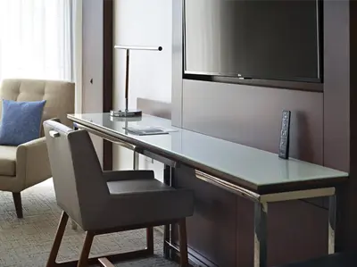 a desk in a hotel room with a chair and a television at Marriott at the University of Dayton in Dayton