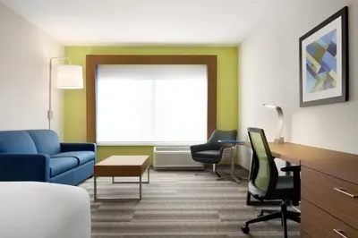 a waiting room with a blue couch and chairs at Holiday Inn Express & Suites - Cincinnati South - Wilder by IHG in Wilder