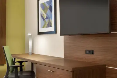 a desk with a tv and a chair in a room at Holiday Inn Express & Suites - Cincinnati South - Wilder by IHG in Wilder
