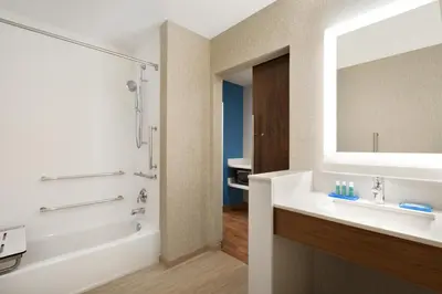 a bathroom with a sink and a tub and a mirror at Holiday Inn Express & Suites - Cincinnati South - Wilder by IHG in Wilder