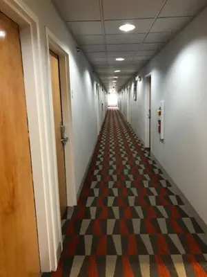 a long hallway with a checkerboard patterned floor at Microtel Inn & Suites by Wyndham Pittsburgh Airport in Robinson Township