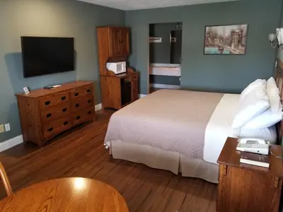 a hotel room with a bed and a flat screen tv at Brown's Motel in Aberdeen