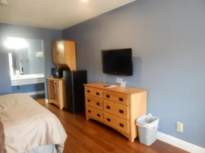 a bedroom with a bed and a flat screen tv at Brown's Motel in Aberdeen
