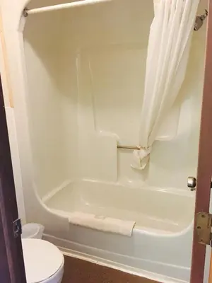 a bathroom with a white tub and a toilet at Brown's Motel in Aberdeen