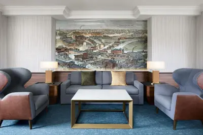 a living room with couches and a large painting on the wall at Hotel Cleveland Autograph Collection in Cleveland