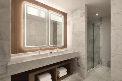 a bathroom with a sink and a glass shower at Hotel Cleveland Autograph Collection in Cleveland