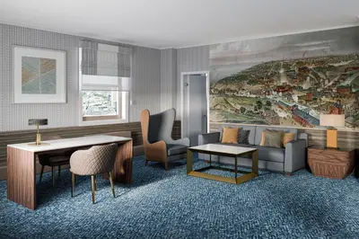 a living room with a couch and a table and chairs at Hotel Cleveland Autograph Collection in Cleveland