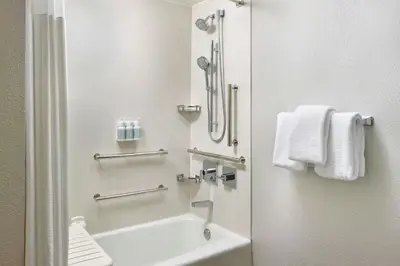 a bathroom with a tub and a sink and towels at Courtyard Cleveland Airport North in North Olmsted