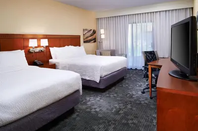 a hotel room with two beds and a flat screen tv at Courtyard Columbus Dublin in Dublin