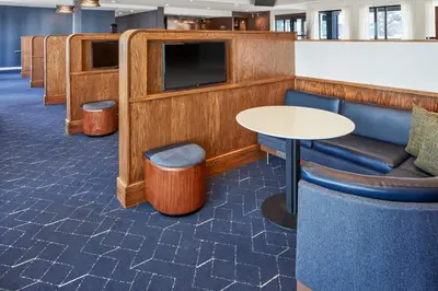 a waiting room with a tv and a table and chairs at Courtyard Columbus Dublin in Dublin