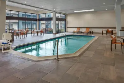 a pool in a hotel lobby with tables and chairs at Courtyard Columbus Dublin in Dublin