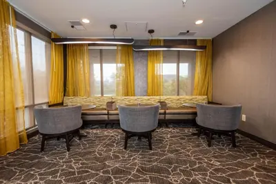 a conference room with a table and chairs and windows at SpringHill Suites Columbus Airport Gahanna in Gahanna