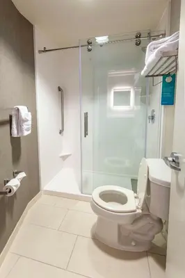 a bathroom with a toilet and a glass shower at SpringHill Suites Columbus Airport Gahanna in Gahanna