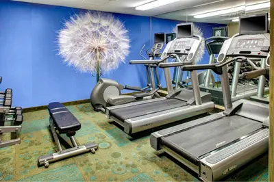 a gym with several tread machines and a blue wall at SpringHill Suites Columbus Airport Gahanna in Gahanna