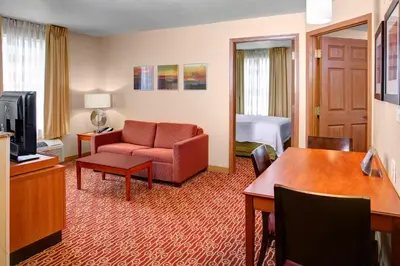 a hotel room with a couch and a room with a bed at TownePlace Suites Columbus Airport Gahanna in Gahanna