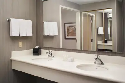 a bathroom with two sinks and a large mirror at Courtyard Cincinnati Covington in Covington