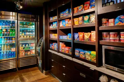 a kitchen with a refrigerator and lots of food at Courtyard Cincinnati Covington in Covington