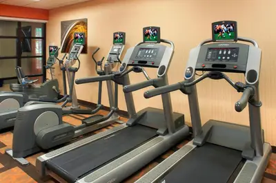 a gym with several tread machines in a room at Courtyard Cincinnati Covington in Covington
