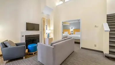 a hotel room with a bed and a living room at Sonesta ES Suites Cincinnati - Sharonville West in Sharonville
