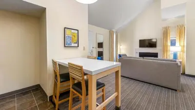 a living room with a table and chairs and a couch at Sonesta ES Suites Cincinnati - Sharonville West in Sharonville