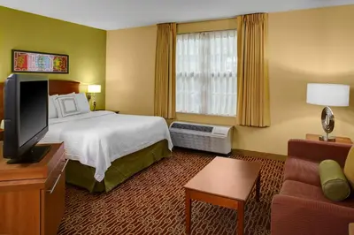 a hotel room with a bed and a flat screen tv at Hawthorn Extended Stay by Wyndham Cincinnati NE Mason in Mason