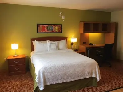 a bedroom with a large bed and two lamps on tables at Hawthorn Extended Stay by Wyndham Cincinnati NE Mason in Mason