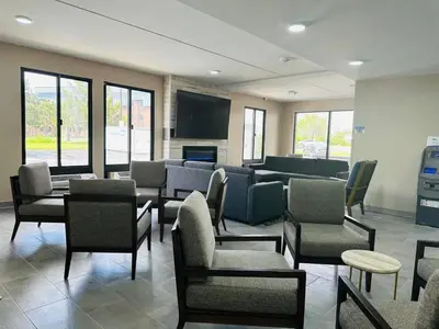 a waiting room with chairs and tables and a screen at Townhouse Near Hall Of Fame Canton I 77 in Canton