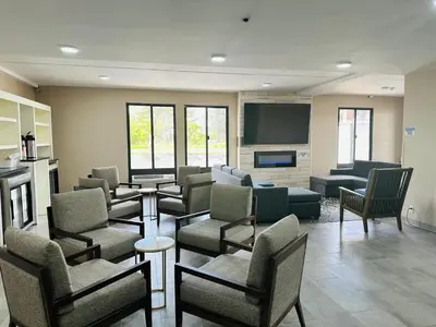 a waiting room with couches and chairs and a tv at Townhouse Near Hall Of Fame Canton I 77 in Canton