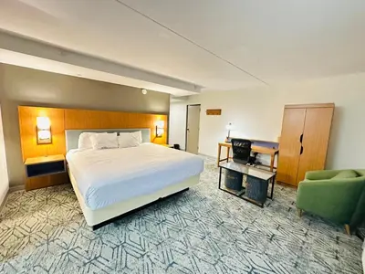 a hotel room with a bed and a green chair at Townhouse Near Hall Of Fame Canton I 77 in Canton