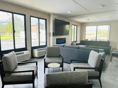 a waiting room with a couch and chairs and a flat screen tv at Townhouse Near Hall Of Fame Canton I 77 in Canton