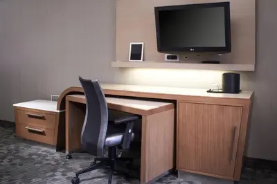a desk with a chair and a television on a wall at Courtyard Cleveland Independence in Independence