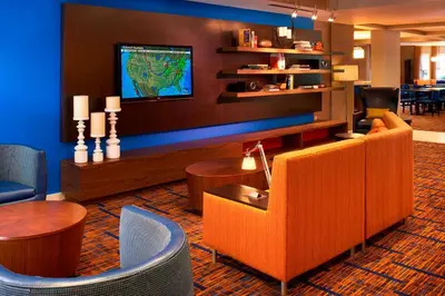 a lobby with a couch and a tv on a wall at Courtyard Cleveland Independence in Independence