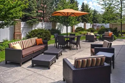 a patio with couches and tables and an umbrella at Courtyard Cleveland Independence in Independence