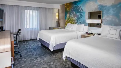 a hotel room with two beds and a desk at Courtyard by Marriott Cleveland Westlake in Westlake