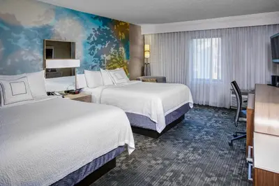 a hotel room with two beds and a desk at Courtyard by Marriott Cleveland Westlake in Westlake