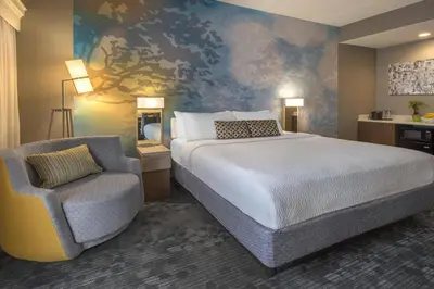 a hotel room with a bed and a chair at Courtyard by Marriott Cleveland Westlake in Westlake