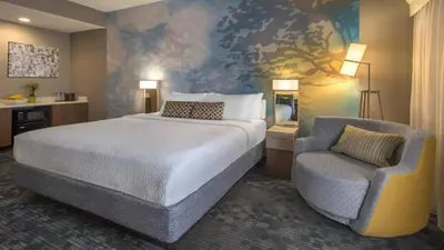 a hotel room with a bed and a chair at Courtyard by Marriott Cleveland Westlake in Westlake
